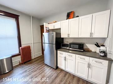 Chicago apartment for rent - A kitchen with white cabinets and a stainless steel refrigerator.