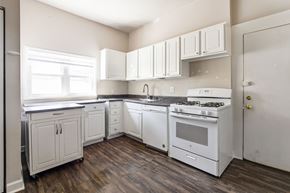 Chicago apartment for rent - A white kitchen with wood floors and white appliances.