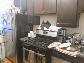 Chicago apartment for rent - A kitchen with a black stove top oven and a black refrigerator.