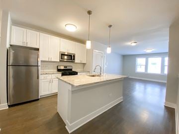 Chicago apartment for rent - A kitchen with white cabinets and a stainless steel refrigerator.