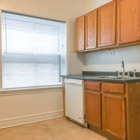 Evanston apartment for rent - A kitchen with wooden cabinets and a white dishwasher.