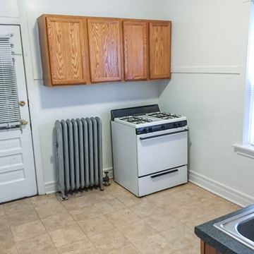 Evanston apartment for rent - A white stove and oven in a kitchen with wooden cabinets.