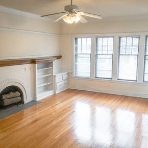 Evanston apartment for rent - A room with a fireplace and a ceiling fan.