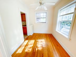 Evanston apartment for rent - A room with a ceiling fan and wooden floors.