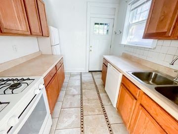Evanston apartment for rent - A kitchen with a white stove and wooden cabinets.