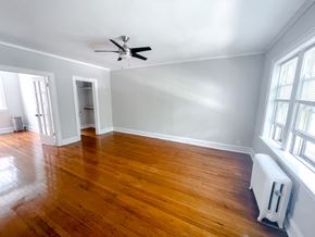 Evanston apartment for rent - A room with wooden floors and a ceiling fan.