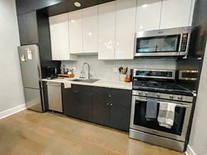 Chicago apartment for rent - A modern kitchen with black cabinets and stainless steel appliances.