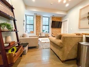 Chicago apartment for rent - A living room with a couch, a chair, and a table.