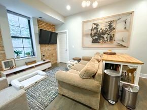 Chicago apartment for rent - A living room with a couch, a coffee table, and a painting on the wall.