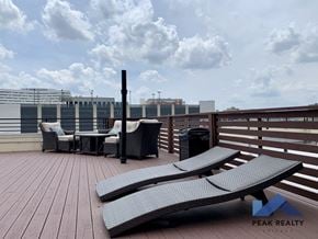 Chicago apartment for rent - a roof top deck with lounge chairs and a fire pit