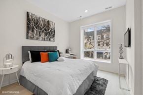 Chicago apartment for rent - a bedroom with a bed and a large window