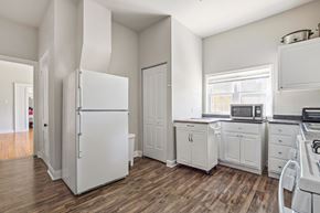 Chicago apartment for rent - A white kitchen with wood floors and white appliances.