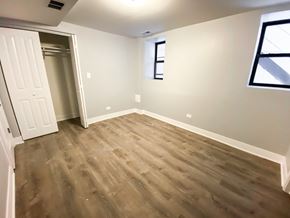 Chicago apartment for rent - A room with a wooden floor and a white door.