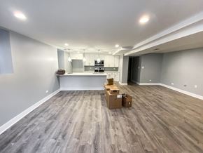 Chicago apartment for rent - A room with wooden flooring and a kitchen area in the background.