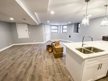 Chicago apartment for rent - A kitchen with a white sink and wooden floors.