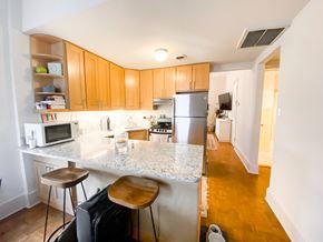 Chicago apartment for rent - A kitchen with a white counter top and wooden cabinets.