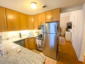 Chicago apartment for rent - A kitchen with wooden cabinets and a stainless steel refrigerator.
