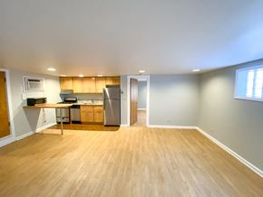 Chicago apartment for rent - A kitchen with wooden floors and a refrigerator.