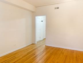 Chicago apartment for rent - A room with a white door and wooden flooring.