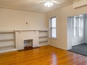 Chicago apartment for rent - A room with a fireplace and wooden floors.