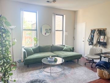 Chicago apartment for rent - A living room with a green couch and a glass table.
