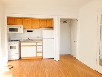 Evanston apartment for rent - A kitchen with white appliances and wooden cabinets.