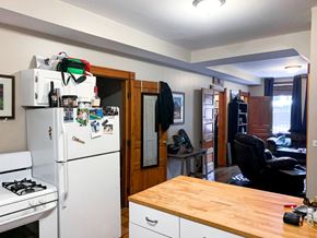 Chicago apartment for rent - A small kitchen with a white fridge and a wooden table.