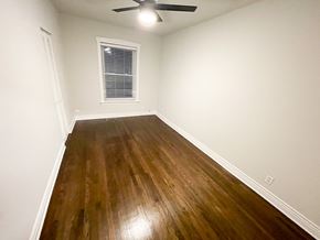 Chicago apartment for rent - A room with a wooden floor and a ceiling fan.
