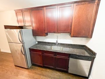 Chicago apartment for rent - A kitchen with wooden cabinets and a stainless steel refrigerator.