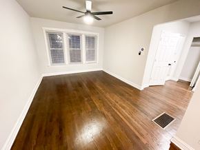 Chicago apartment for rent - A room with a ceiling fan and wooden flooring.
