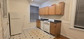 Chicago apartment for rent - A kitchen with white appliances and wooden cabinets.