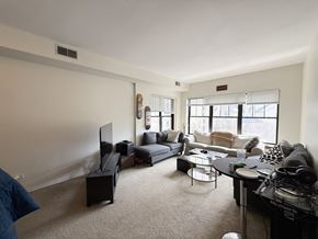 Chicago apartment for rent - A living room with a grey couch, a black coffee table, and a flat screen TV.