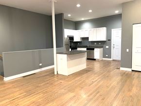 Chicago apartment for rent - an open kitchen and living room with wood flooring and gray walls
