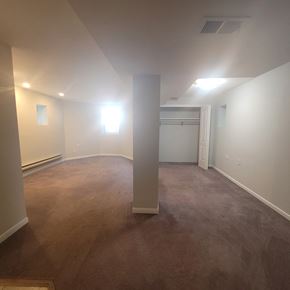 Chicago apartment for rent - an empty living room with a carpeted floor and white walls
