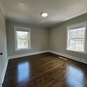 Chicago apartment for rent - A room with wooden floors and two windows.
