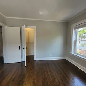 Chicago apartment for rent - A room with a white door and a window with a view of a tree.