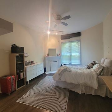 Chicago apartment for rent - A bedroom with a bed, dresser, and a ceiling fan.