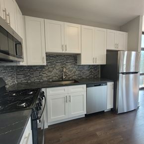 Chicago apartment for rent - a kitchen with white cabinets and stainless steel appliances