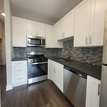 Chicago apartment for rent - a kitchen with white cabinets and stainless steel appliances