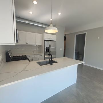 Chicago apartment for rent - A kitchen with white cabinets and a large island.