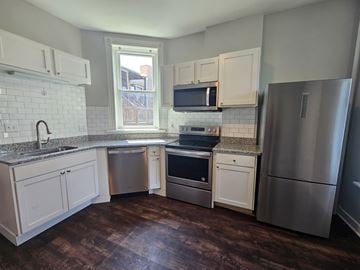 Chicago apartment for rent - A kitchen with white cabinets and a stainless steel refrigerator.