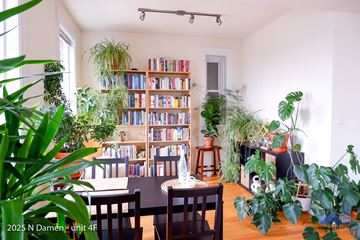 Chicago apartment for rent - A living room with a bookshelf filled with books and potted plants.