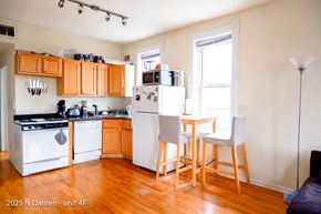Chicago apartment for rent - A kitchen with orange cabinets and white appliances.