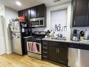 Chicago apartment for rent - A kitchen with black cabinets and a stainless steel dishwasher.