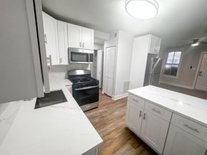 Chicago apartment for rent - A modern kitchen with white cabinets and stainless steel appliances.