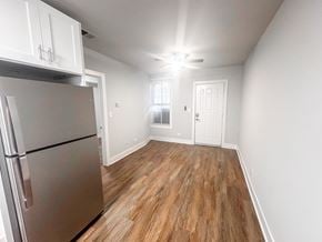 Chicago apartment for rent - A kitchen with a refrigerator and wooden floors.