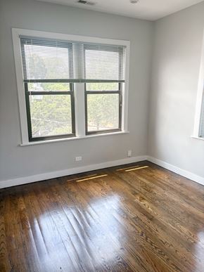Chicago apartment for rent - A room with a window and wooden flooring.