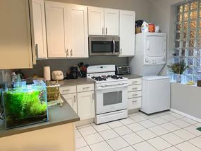 Chicago apartment for rent - A kitchen with white appliances and a fish tank on the counter.