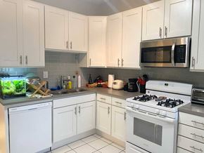 Chicago apartment for rent - A white kitchen with a stove, dishwasher, and microwave.