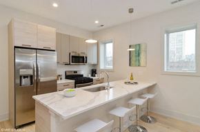 Chicago apartment for rent - A modern kitchen with a white countertop and stainless steel appliances.